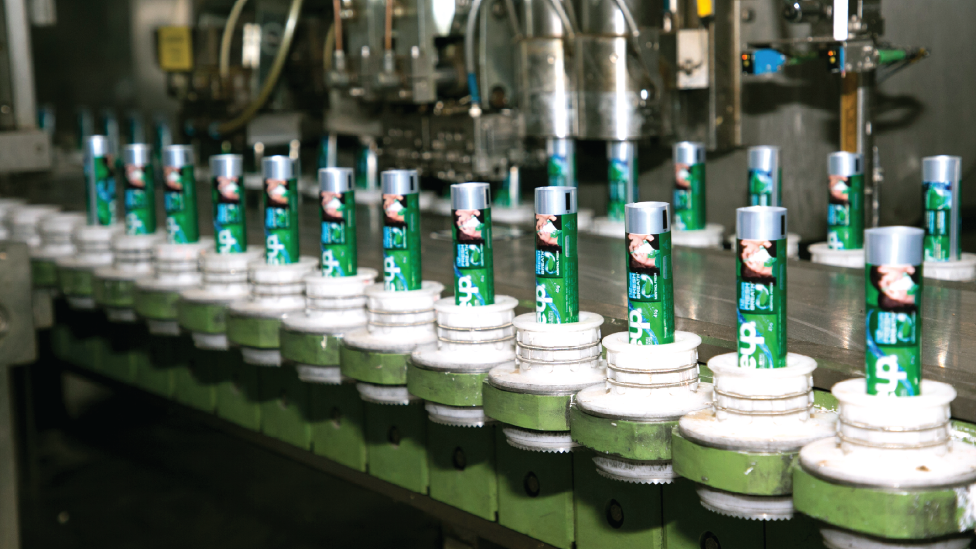 স্বয়ংক্রিয় উৎপাদন বেল্টের টিউবগুলিতে ক্লোজ আপ টুথপেস্ট ঢোকানো হচ্ছে।